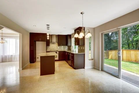 Modern kitchen room with matte brown cabinets and exit to backyard Stock Photos