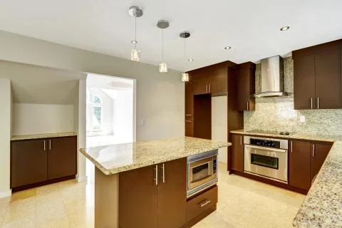 Modern kitchen room with matte brown cabinets and granite trim. Stock Photos