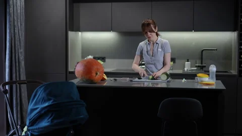 A modern kitchen scene featuring a person who is actively preparing delicious Stock Footage 301436190