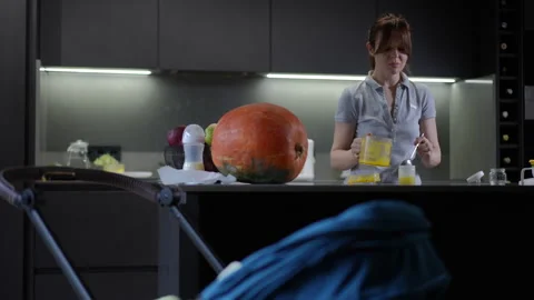 In a modern kitchen setting, a woman is surrounded by unique squash and vibrant  Stock Footage 301437800