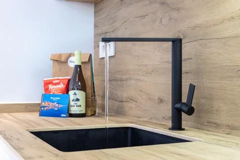Modern Kitchen Sink With Matte Black Faucet And Running Water Stock Photos