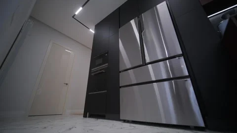 A modern kitchen with sleek black cabinetry, stainless steel appliances Stock Footage 270093569