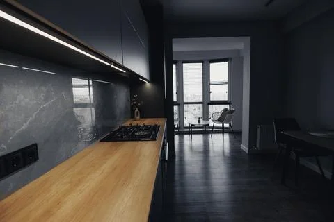 Modern kitchen with sleek black cabinets and wood counter Foto stock