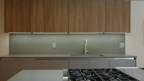 Modern kitchen with sleek design. Kitchen features wooden upper cabinets, light Stock Footage 294853967