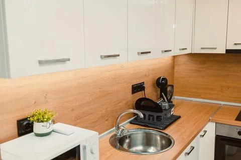 Modern kitchen space with clean design and simple layout featuring a sink, .. Stock Photos