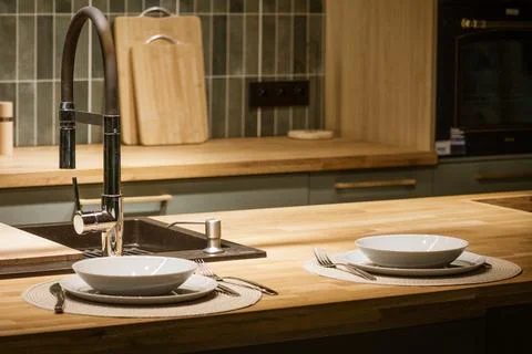 Modern kitchen table setting with wooden counter Stock Photos