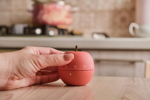 Modern kitchen timer apple shaped on the background of the kitchen Stock Photos