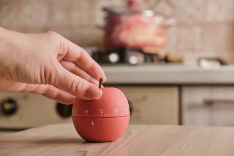 Modern kitchen timer apple shaped on the background of the kitchen Stock Photos