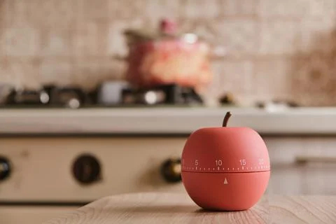 Modern kitchen timer apple shaped on the background of the kitchen Stock Photos