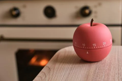Modern kitchen timer apple shaped on the background of the kitchen Stock Photos