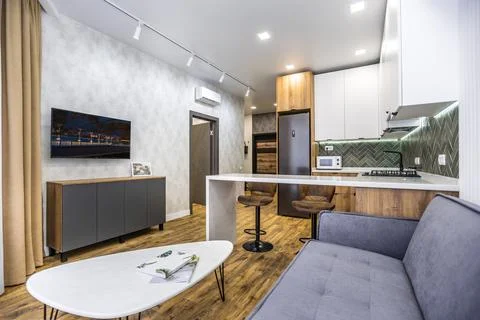 A modern kitchen with a white coffee table and a grey couch Stock Photos