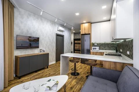 A modern kitchen with a white coffee table and a grey couch Stock Photos