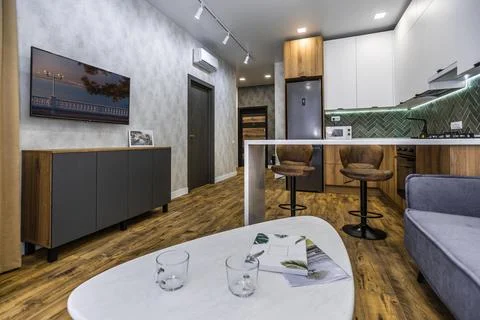 A modern kitchen with a white coffee table and a grey couch Stock Photos