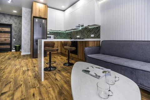 A modern kitchen with a white coffee table and a grey couch Stock Photos