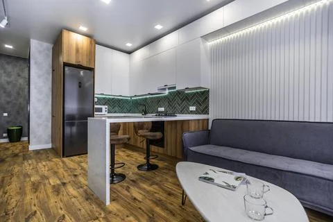 A modern kitchen with a white coffee table and a grey couch Stock Photos