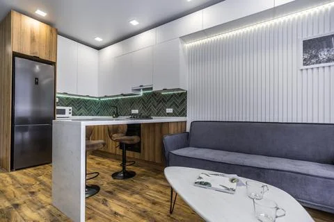 A modern kitchen with a white coffee table and a grey couch Stock Photos