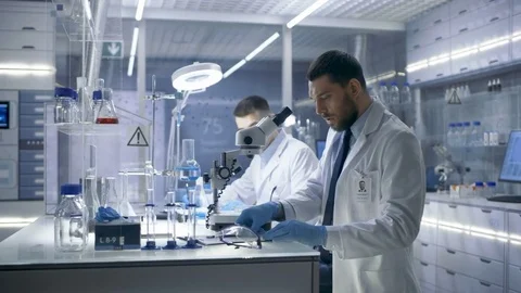 In a Modern Laboratory Two Scientists Conduct Experiments.  Stock Footage 75436734