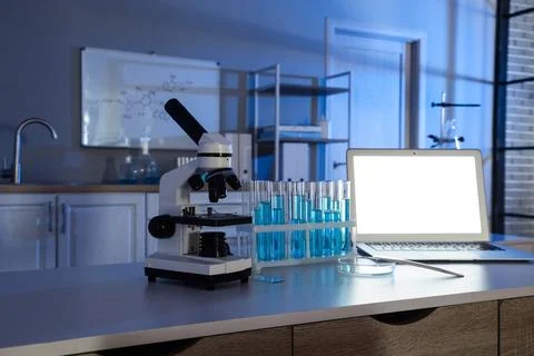 Modern laboratory workspace with microscope, test tubes, and laptop for scien Stock Photos