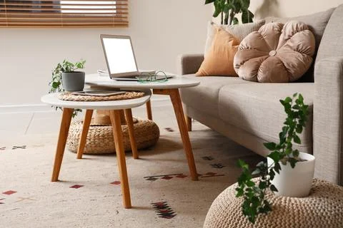 Modern laptop and tablet computer on coffee table in interior of living room Stock Photos