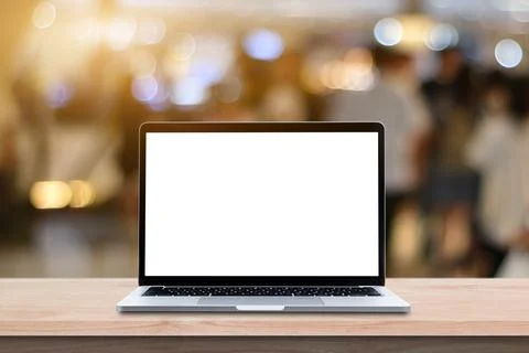 Modern Laptop computer with blank screen on wood table over blur bokeh light  Stock Photos
