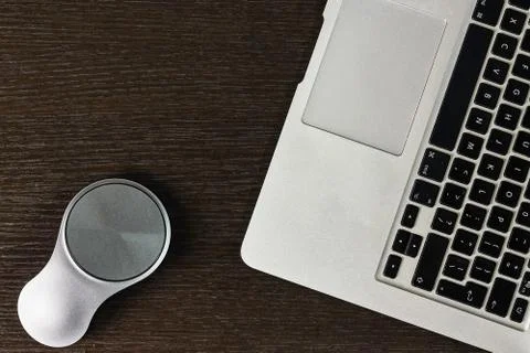 Modern laptop computer with mouse on dark table Stock Photos