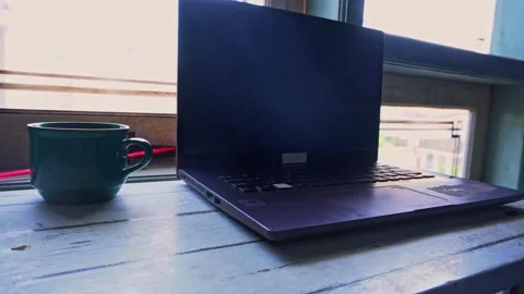 Modern laptop computer placed on a rustic white table next to a steaming ce.. Stock Footage 345138938