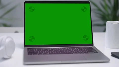 Modern Laptop Computer on White Desk with Blank Empty Green Mockup Screen Stock Footage 251731470