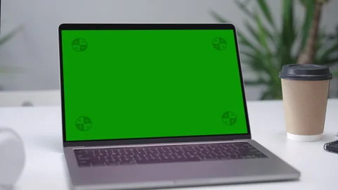 Modern Laptop Computer on White Desk with Blank Empty Green Mockup Screen Stock Footage 252853389