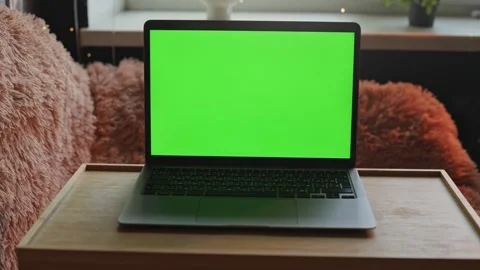 Modern laptop with green screen on a wooden tray table for creative editing Stock Footage 340265211