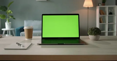 Modern laptop with mock up chroma key green screen st on desk of living room Stock Footage