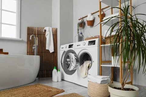 Modern laundry room with washing machine and bathtub Stock Photos