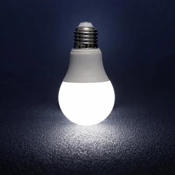 Modern led lamp is turned on a dark background. Stock Photos