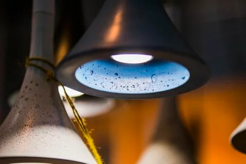 Modern light bulbs in a cafe. Ceiling light fixtures. Chandelier from cement. Stock Photos