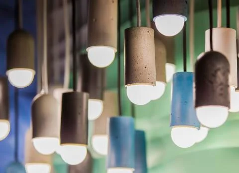 Modern light bulbs in a cafe. Ceiling light fixtures. Chandelier from cement. Stock Photos