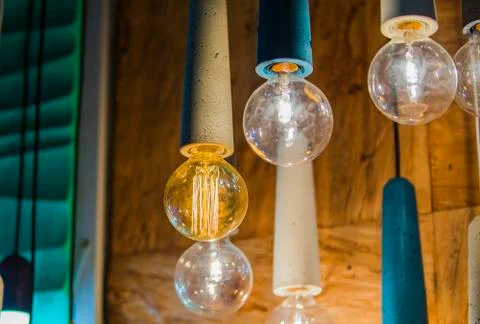 Modern light bulbs in a cafe. Ceiling light fixtures. Chandelier from cement. Stock Photos