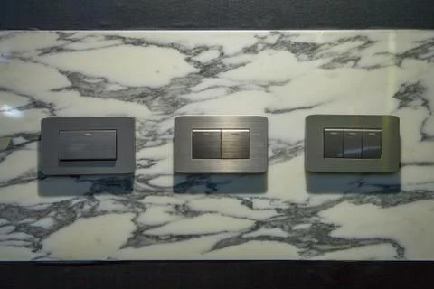 Modern light electrical switch with modern marble background. Stock Photos