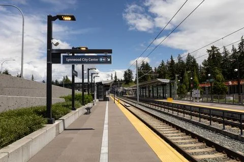 Modern light rail platform with tracks under blue sky Stock Photos