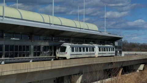 Modern light rail station featuring a train that is currently in motion departs Vidéo 291641467