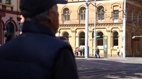 A modern light rail tram glides past Sydney's heritage sandstone facades while Stock Footage 346255578