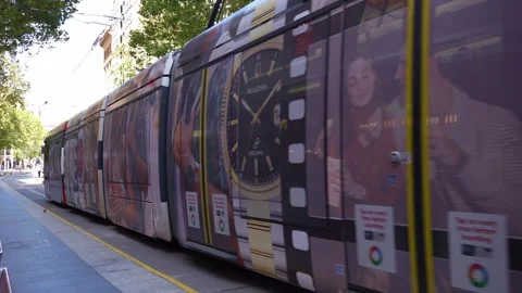 A modern light rail tram pulls into Chinatown station as passengers wait on the Stock Footage 339844477