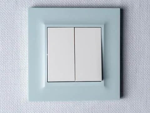 A modern light switch with a blue border is mounted on the wall. Stock Photos