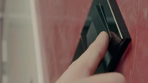 Modern light switch that a man's finger presses and the led lamp lights up Stock Footage 297763031
