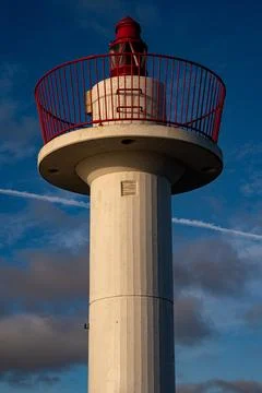 Modern Lighthouse Tower with Red Railing Against a Blue Sky. Stock Photos