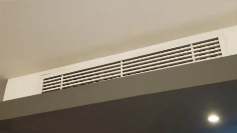 Modern linear air conditioning vent grille installed in a white ceiling bulkhead 스톡 동영상 344092174