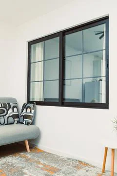 Modern living space with a window view and couch in a simple interior desig.. Stock Photos