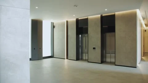 A modern lobby interior featuring sleek design, elevator access, and minimalist Stock Footage 283354130