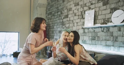 In a modern loft bedroom multi ethnic young ladies in pajamas have a sleepover Stock Footage 105186835