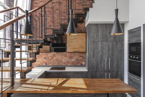 Modern loft kitchen interior with gray cabinets, wooden kitchen island Stock Photos
