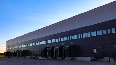 Modern logistics warehouse building with empty numbered loading bays Stock Photos