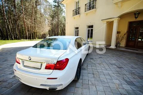 Modern luxury BMW 750Li XDrive car rear back upper view parked on stone paved Stock Photos